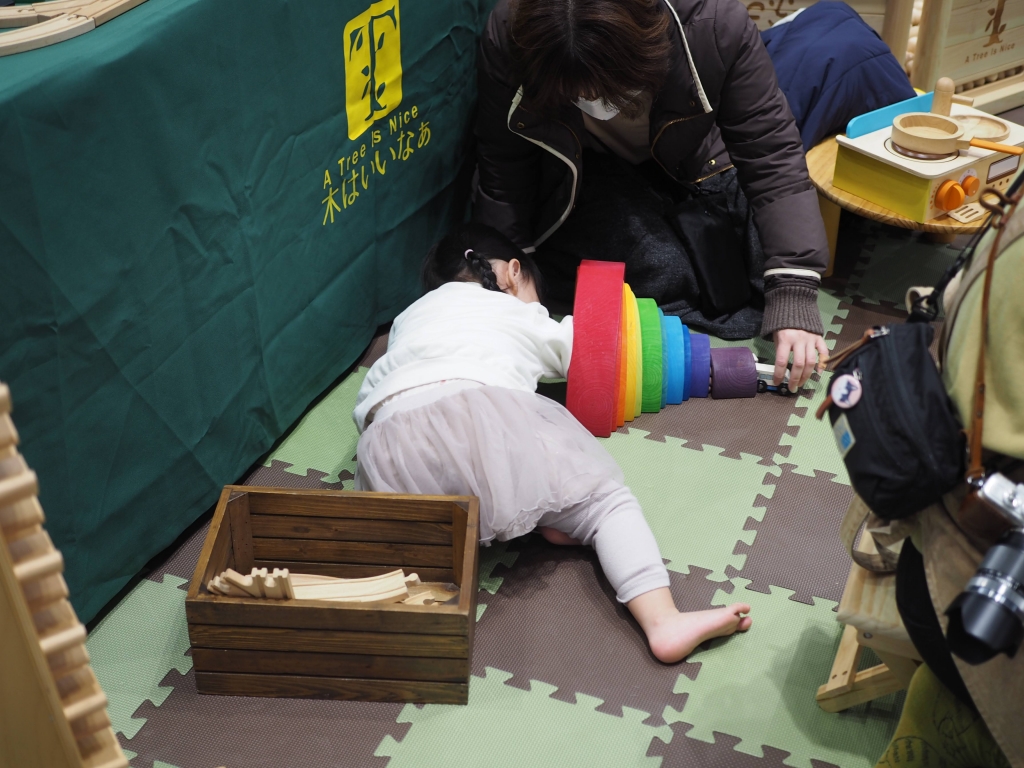 夢メッセみやぎのイベント会場で遊ぶ子供たちと移動木育広場の風景