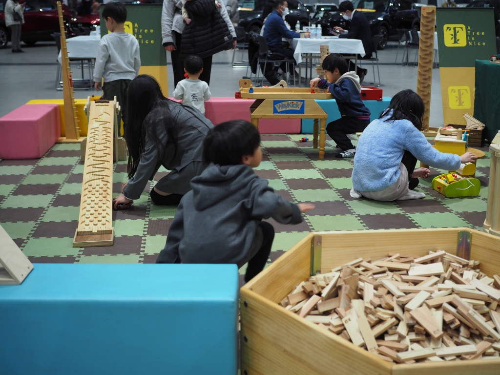 夢メッセみやぎのイベント会場で遊ぶ子供たちと移動木育広場の風景