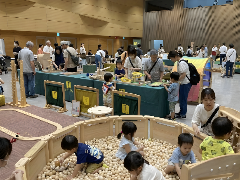 仙台アエルの木のおもちゃひろばで、木の玉ボールプールや様々な木製玩具で遊ぶ大勢の親子連れの様子