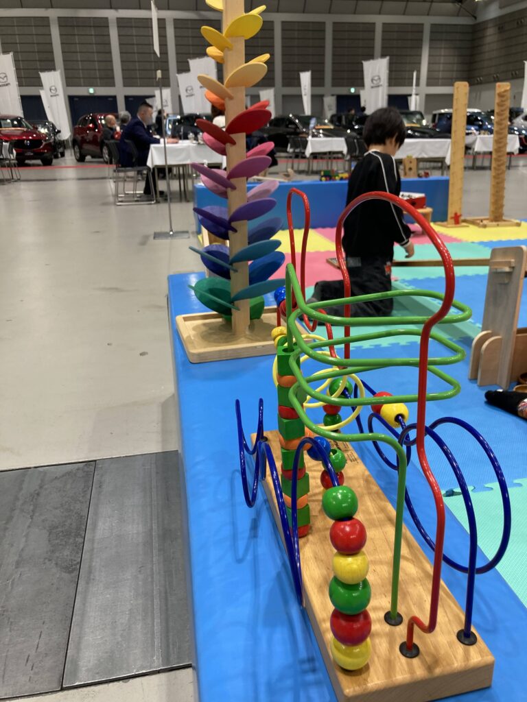 夢メッセみやぎで開催された東北マツダ特別展示会にて、おままごとついたてや木のボールプールで遊ぶ子どもたちの様子