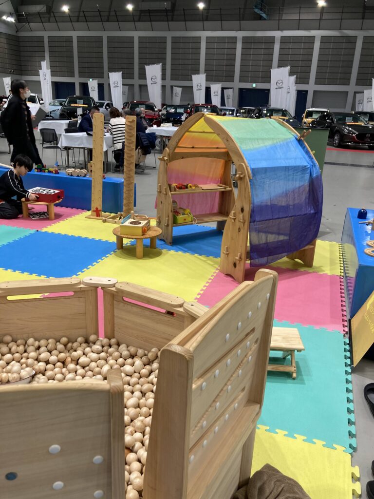夢メッセみやぎで開催された東北マツダ特別展示会にて、おままごとついたてや木のボールプールで遊ぶ子どもたちの様子