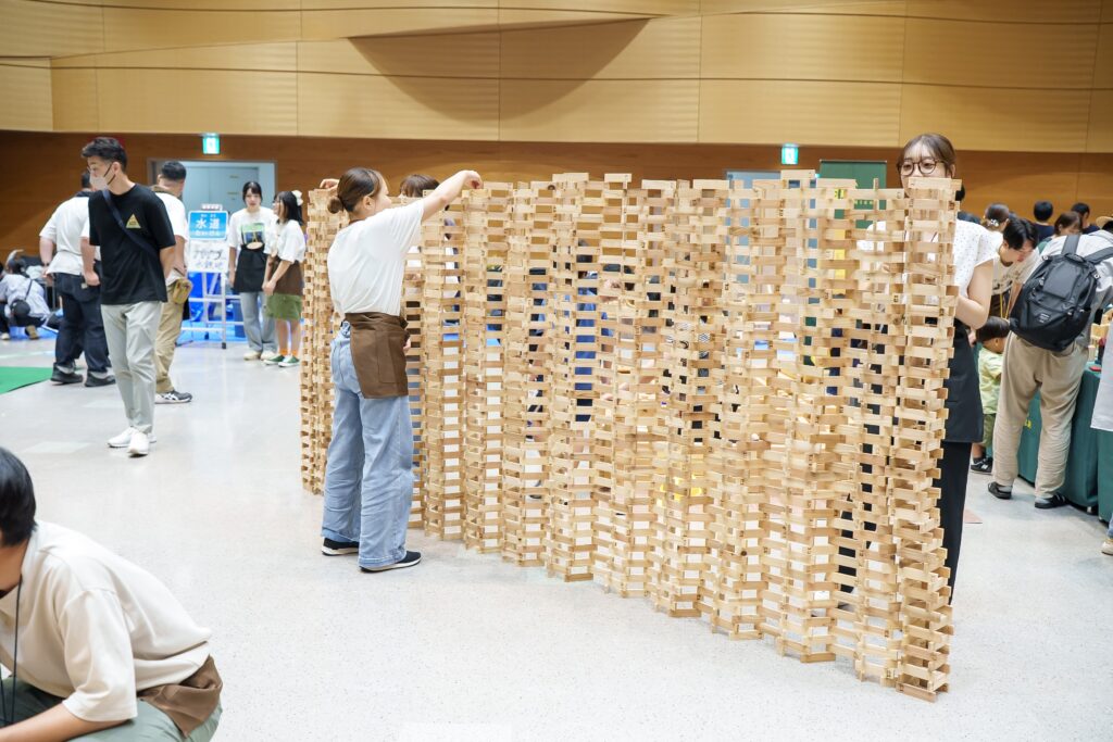 仙台アエルの木のおもちゃひろばで、木の玉ボールプールや様々な木製玩具で遊ぶ大勢の親子連れの様子