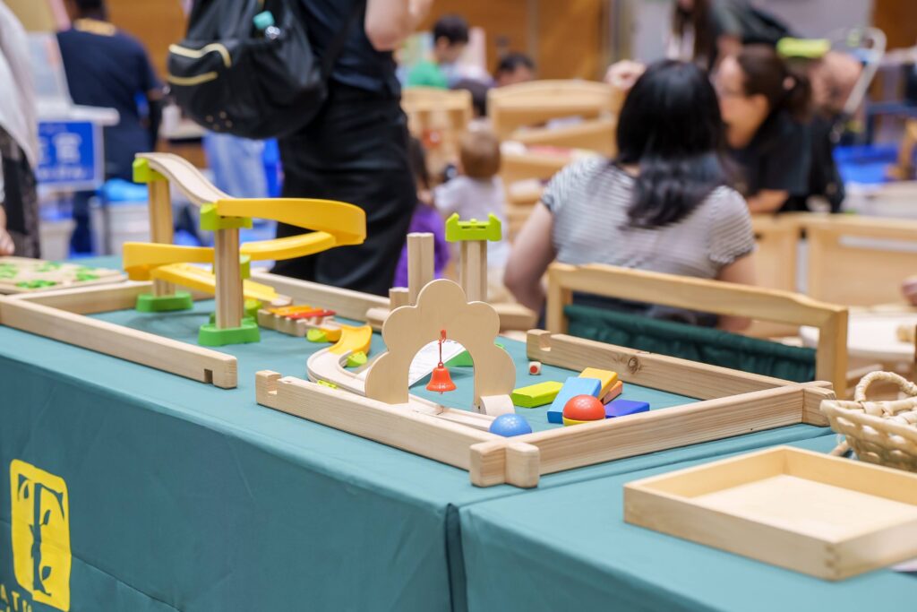 仙台アエルの木のおもちゃひろばで、木の玉ボールプールや様々な木製玩具で遊ぶ大勢の親子連れの様子