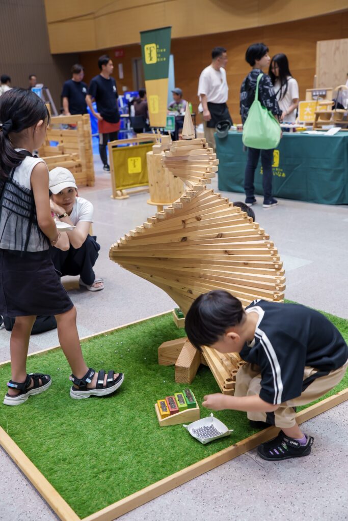 仙台アエルの木のおもちゃひろばで、木の玉ボールプールや様々な木製玩具で遊ぶ大勢の親子連れの様子