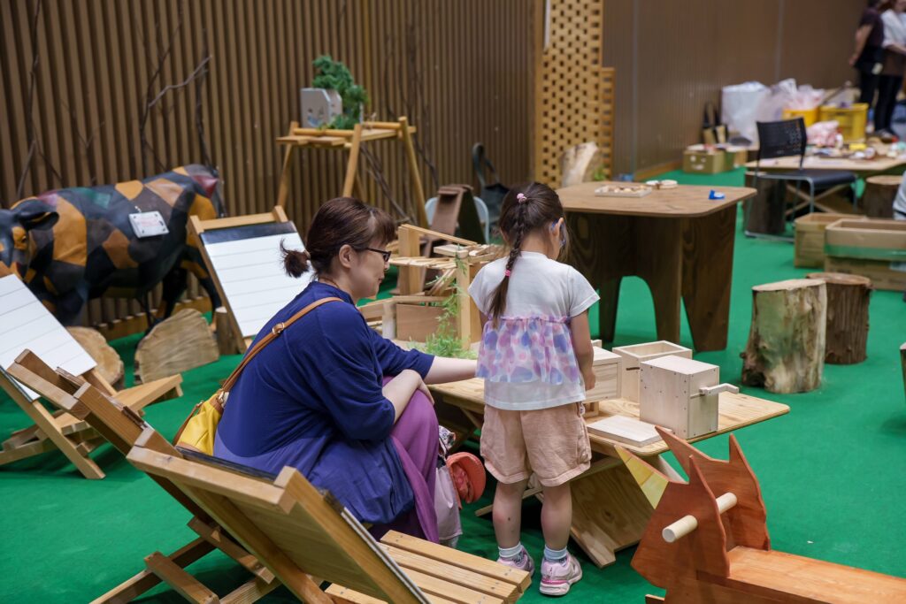 仙台アエルの木のおもちゃひろばで、木の玉ボールプールや様々な木製玩具で遊ぶ大勢の親子連れの様子