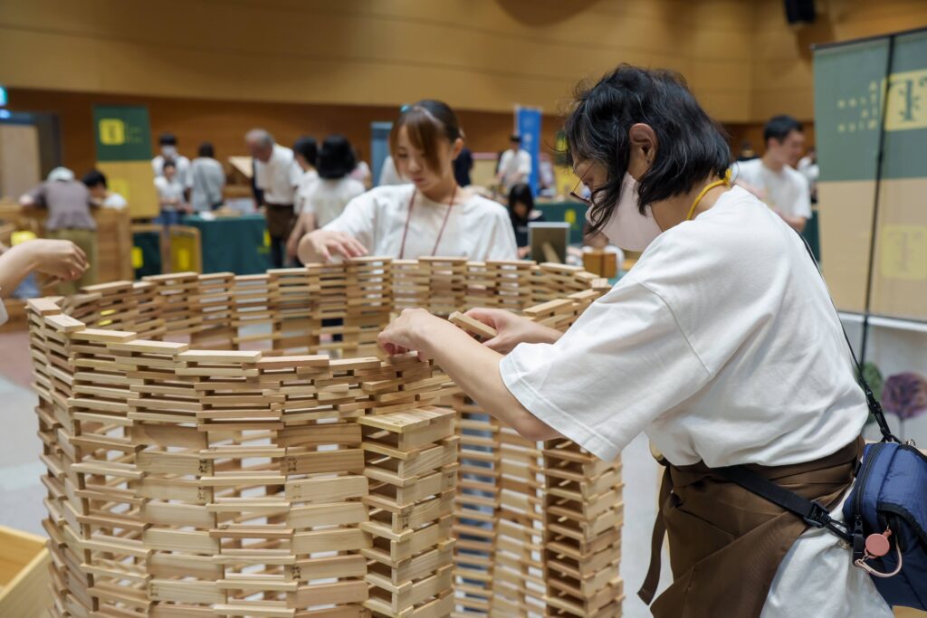 仙台アエルの木のおもちゃひろばで、木の玉ボールプールや様々な木製玩具で遊ぶ大勢の親子連れの様子