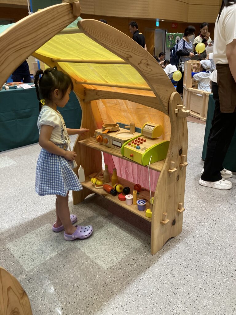 仙台アエルの木のおもちゃひろばで、木の玉ボールプールや様々な木製玩具で遊ぶ大勢の親子連れの様子