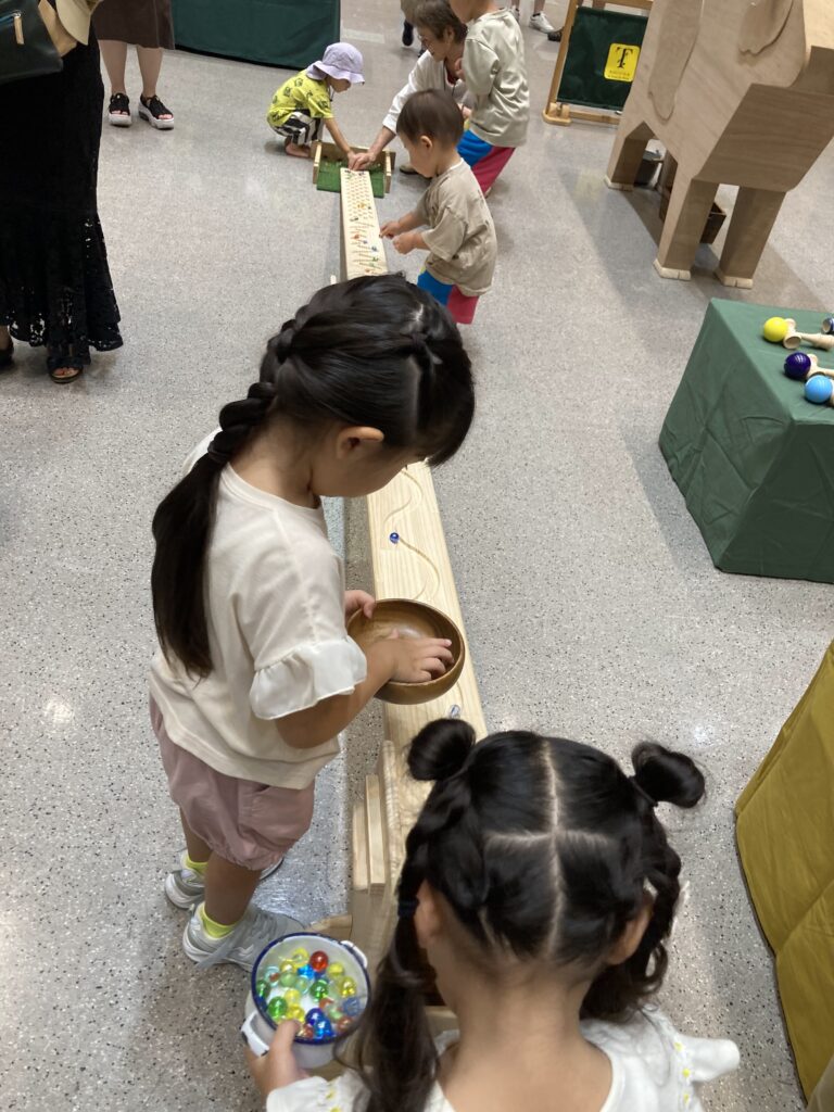 仙台アエルの木のおもちゃひろばで、木の玉ボールプールや様々な木製玩具で遊ぶ大勢の親子連れの様子