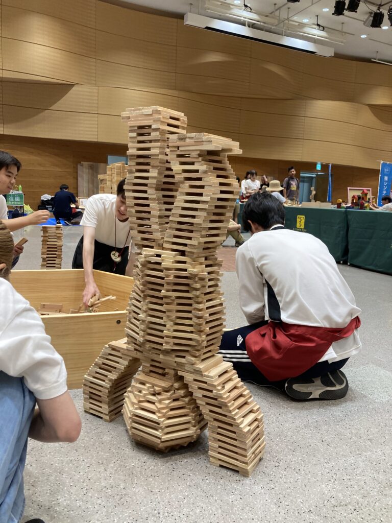 仙台アエルの木のおもちゃひろばで、木の玉ボールプールや様々な木製玩具で遊ぶ大勢の親子連れの様子