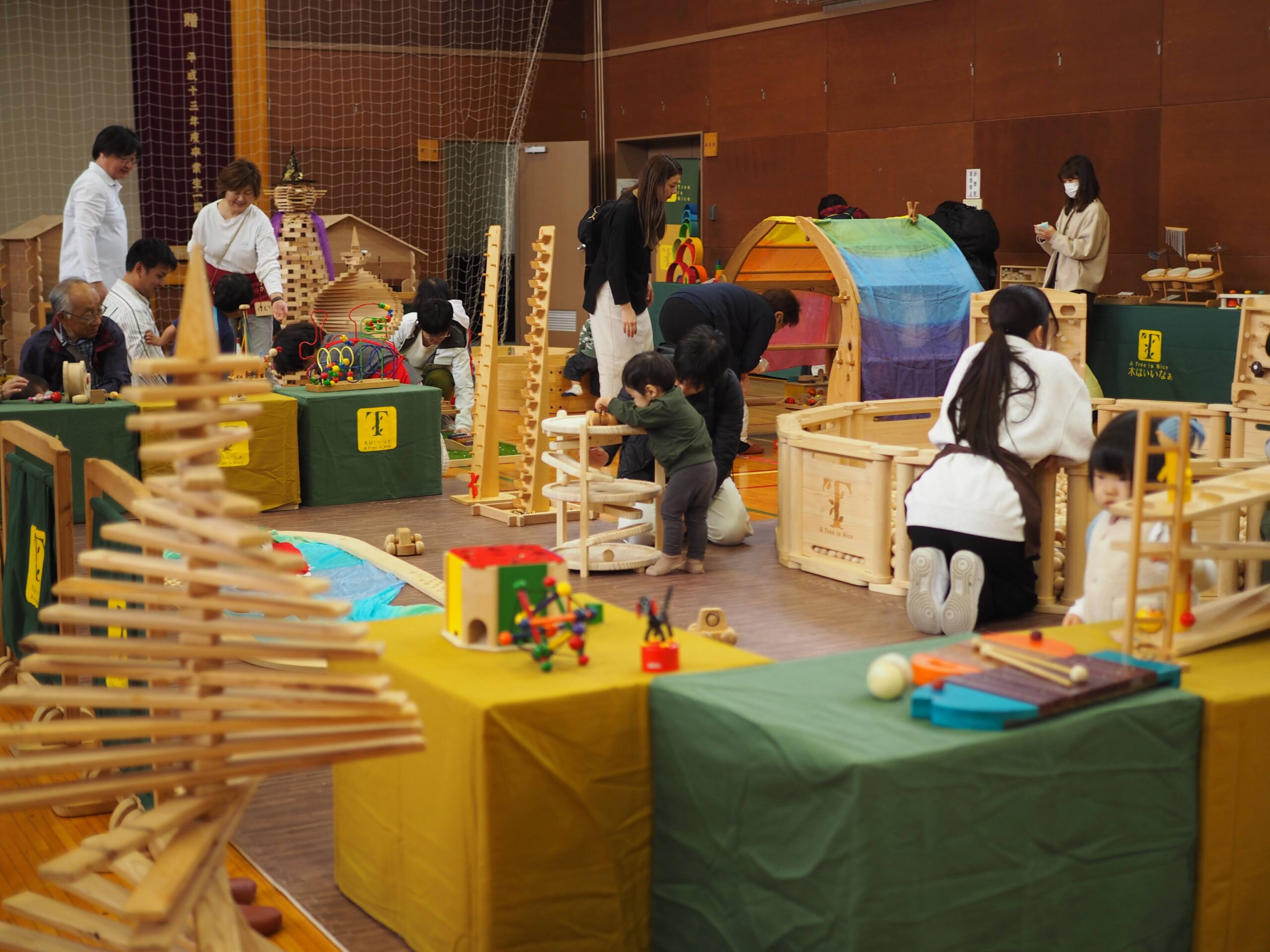 秋保市民センターの大ホールで開催された「おもちゃのひろば」で、木のボールプールや工作を楽しむ親子連れの様子