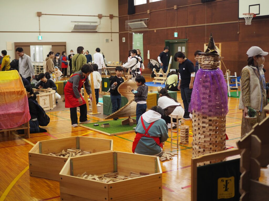 秋保市民センターの大ホールで開催された「おもちゃのひろば」で、木のボールプールや工作を楽しむ親子連れの様子