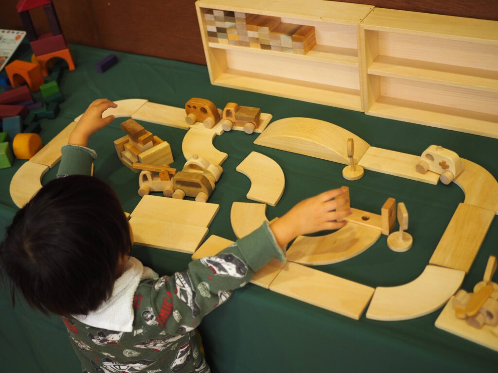 秋保市民センターの大ホールで開催された「おもちゃのひろば」で、木のボールプールや工作を楽しむ親子連れの様子