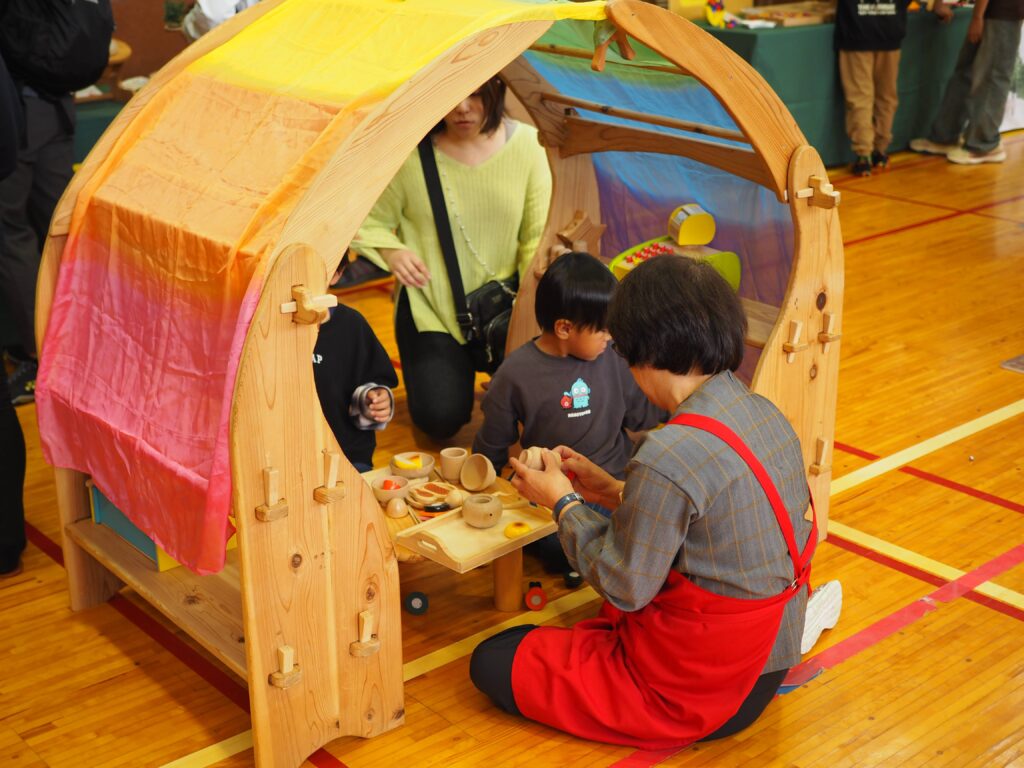 秋保市民センターの大ホールで開催された「おもちゃのひろば」で、木のボールプールや工作を楽しむ親子連れの様子