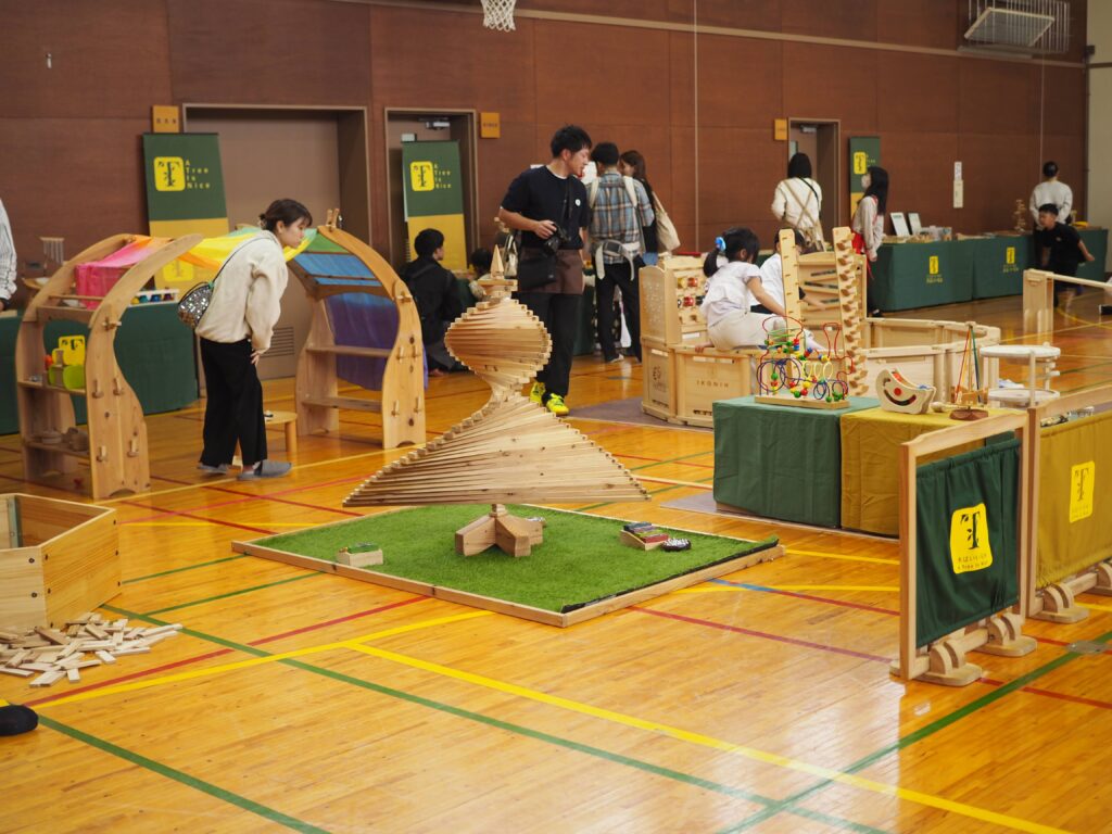 秋保市民センターの大ホールで開催された「おもちゃのひろば」で、木のボールプールや工作を楽しむ親子連れの様子