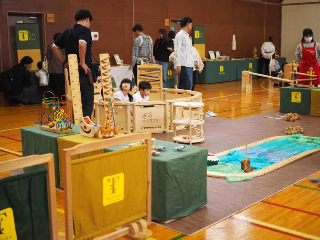 秋保市民センターの大ホールで開催された「おもちゃのひろば」で、木のボールプールや工作を楽しむ親子連れの様子