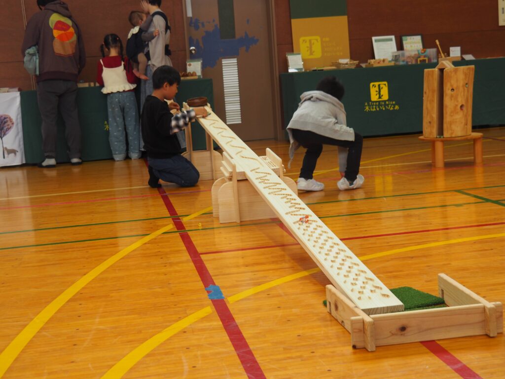 秋保市民センターの大ホールで開催された「おもちゃのひろば」で、木のボールプールや工作を楽しむ親子連れの様子