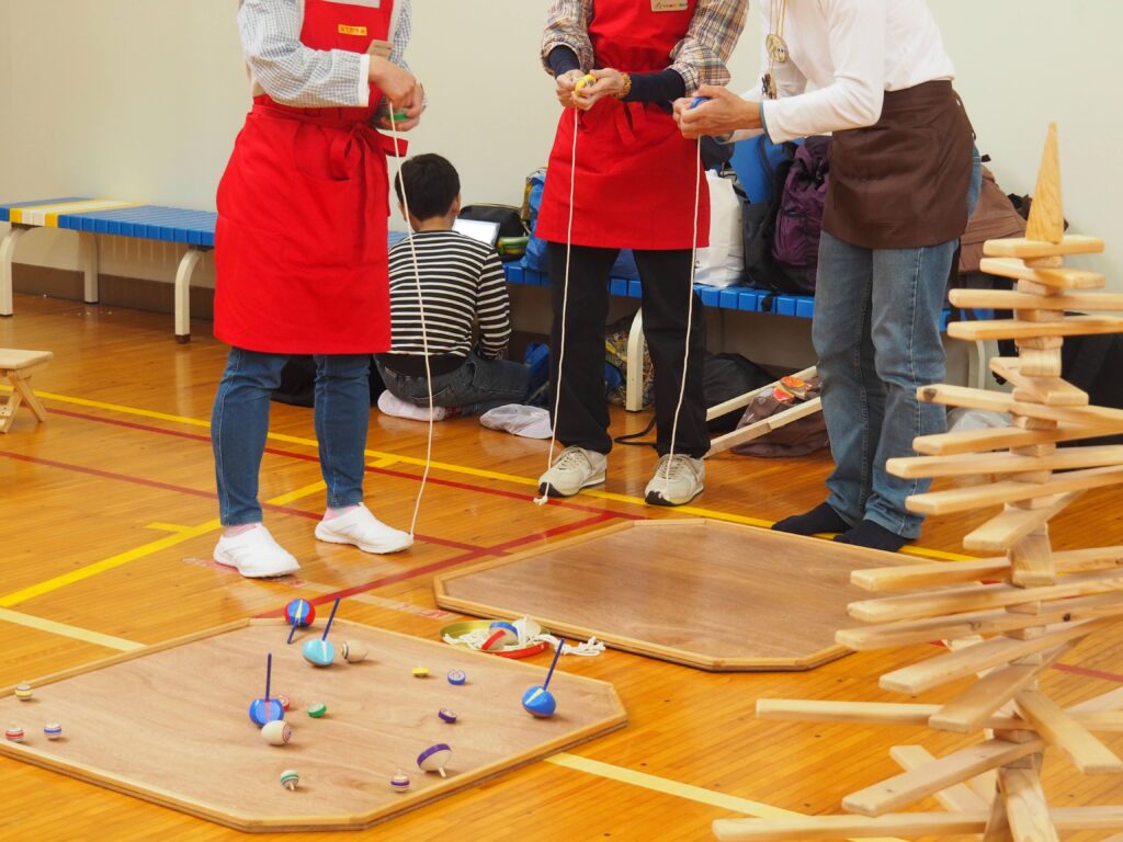 秋保市民センターの大ホールで開催された「おもちゃのひろば」で、木のボールプールや工作を楽しむ親子連れの様子