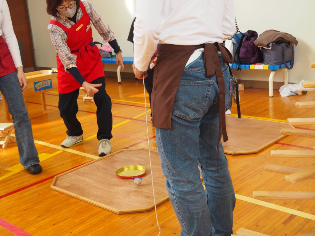 秋保市民センターの大ホールで開催された「おもちゃのひろば」で、木のボールプールや工作を楽しむ親子連れの様子