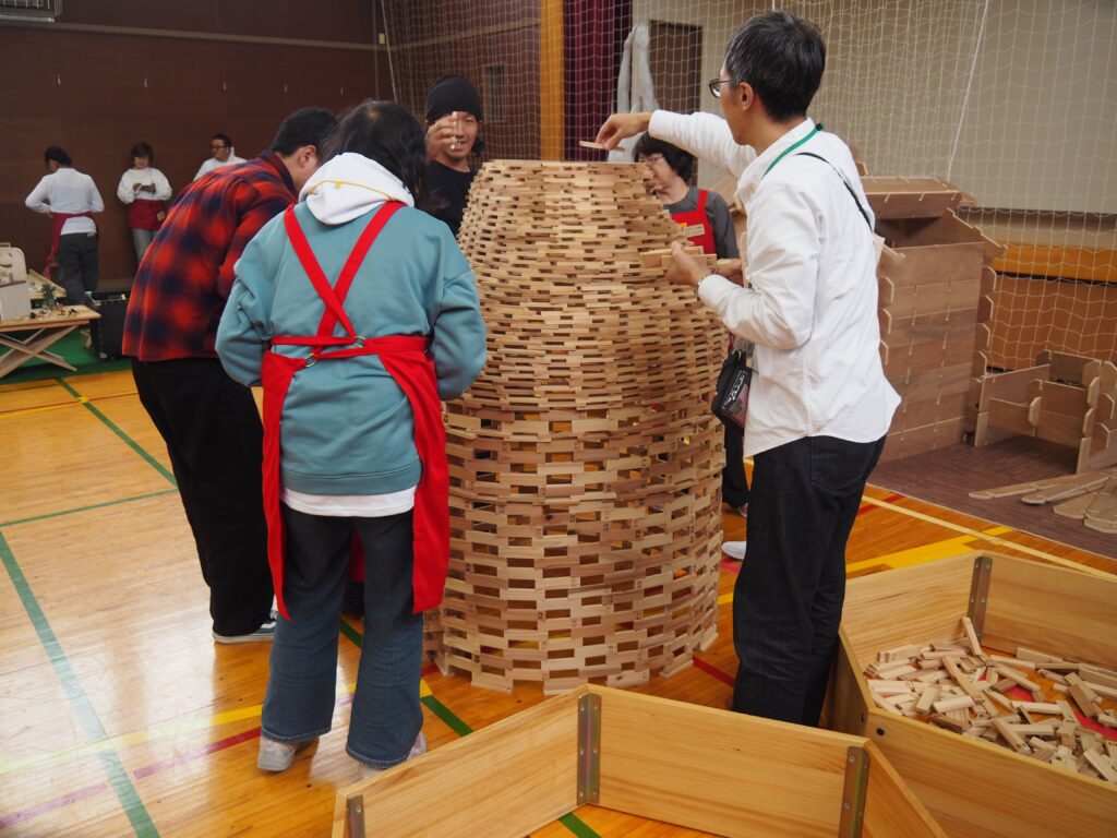 秋保市民センターの大ホールで開催された「おもちゃのひろば」で、木のボールプールや工作を楽しむ親子連れの様子