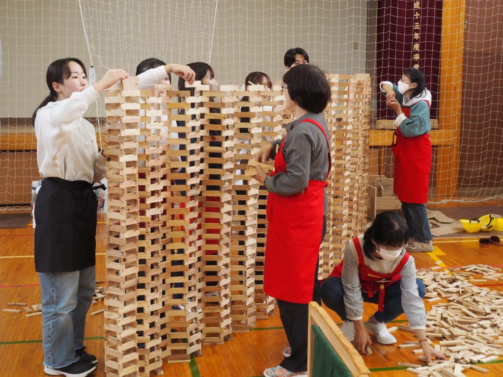 秋保市民センターの大ホールで開催された「おもちゃのひろば」で、木のボールプールや工作を楽しむ親子連れの様子