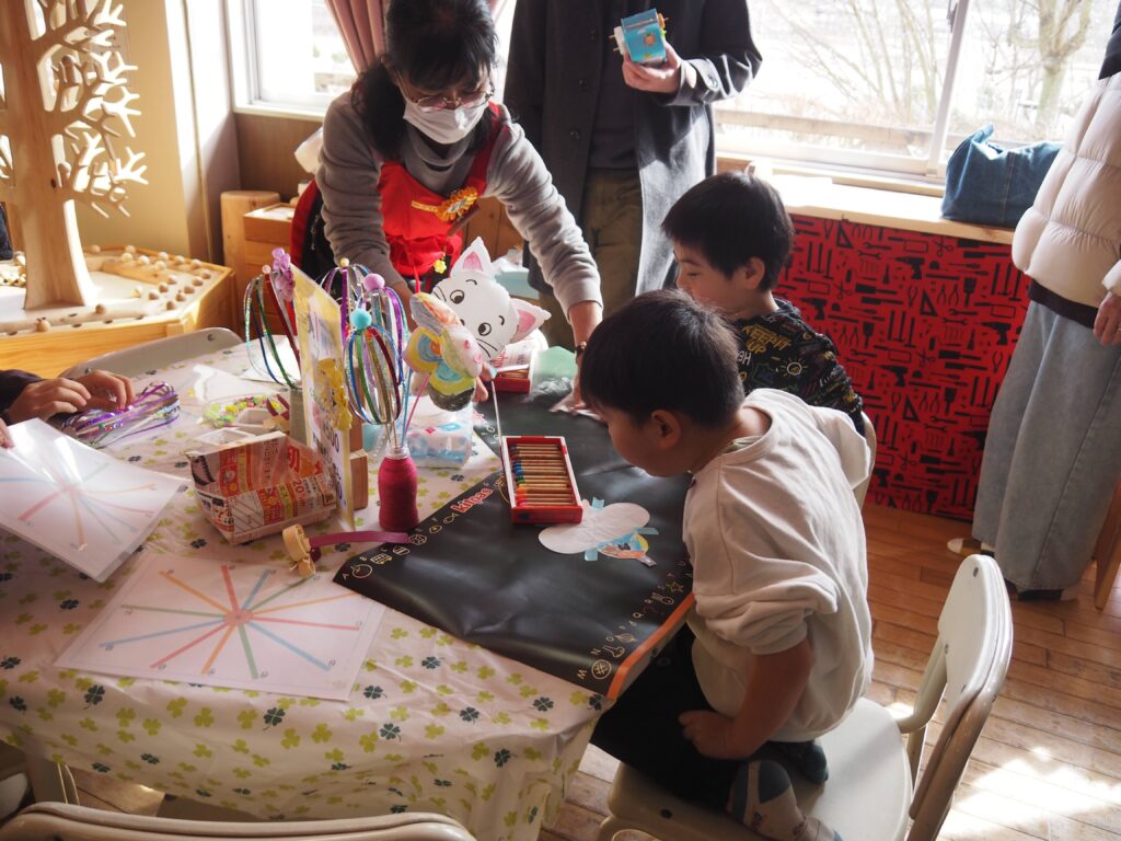 木育広場里山エスクエラの1周年イベントで、おもちゃコンサルタントと子どもたちが積み木やワークショップで遊んでいる賑やかな風景