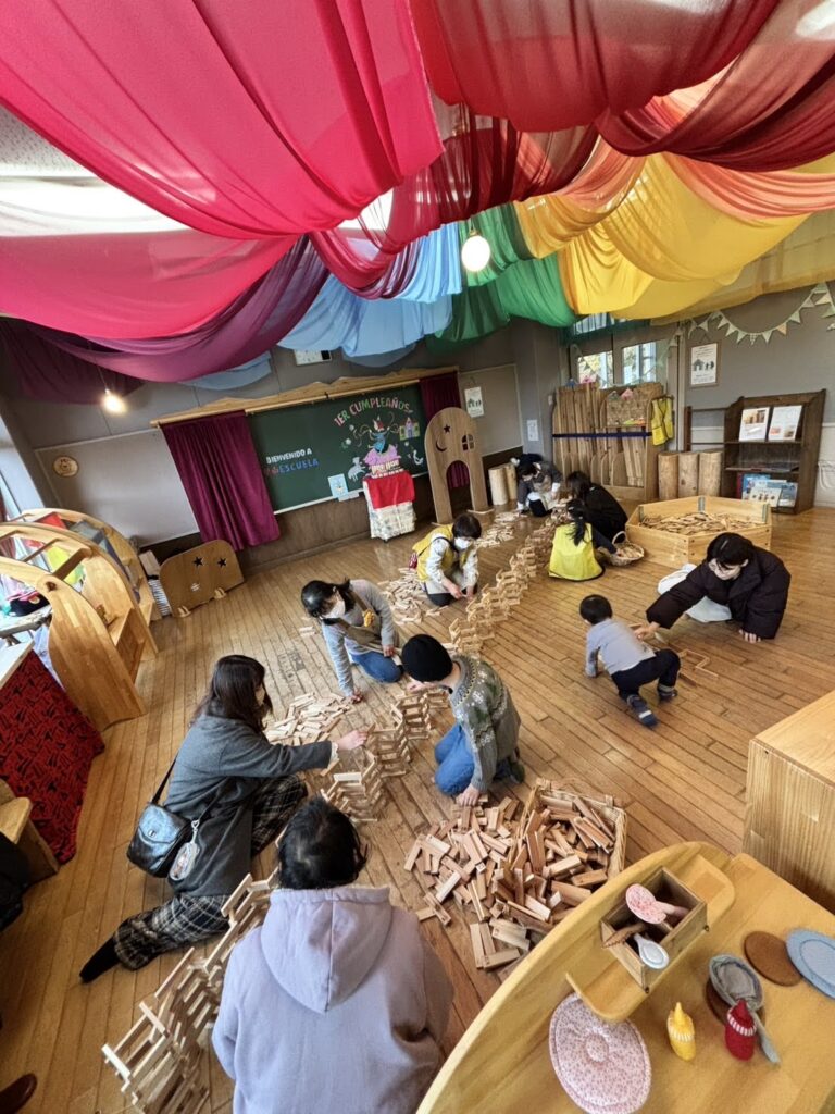 木育広場里山エスクエラの1周年イベントで、おもちゃコンサルタントと子どもたちが積み木やワークショップで遊んでいる賑やかな風景