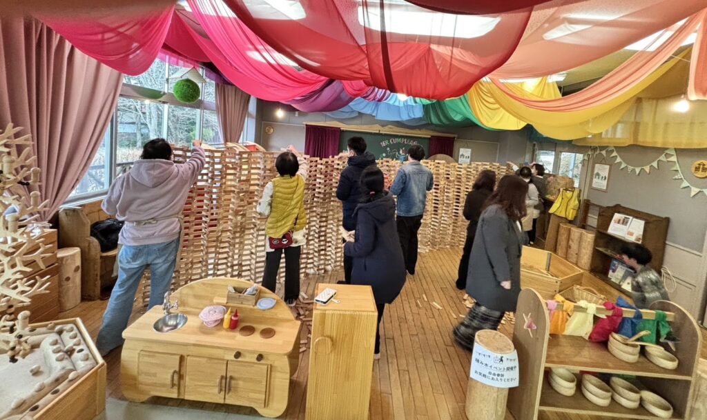 木育広場里山エスクエラの1周年イベントで、おもちゃコンサルタントと子どもたちが積み木やワークショップで遊んでいる賑やかな風景