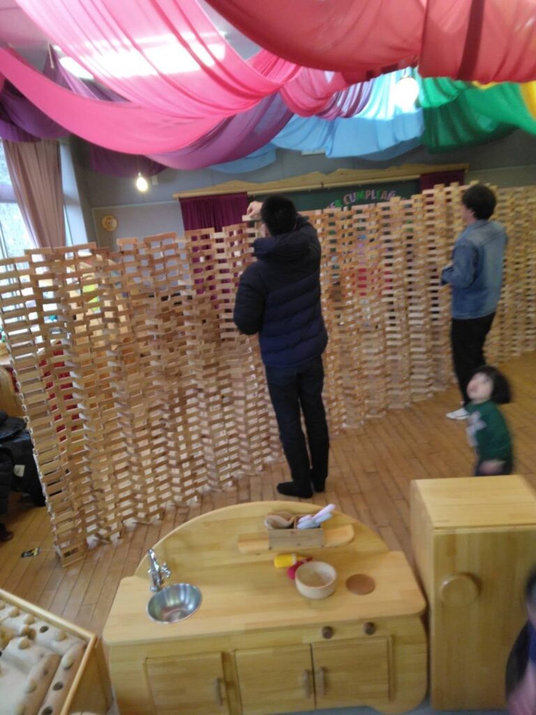 木育広場里山エスクエラの1周年イベントで、おもちゃコンサルタントと子どもたちが積み木やワークショップで遊んでいる賑やかな風景