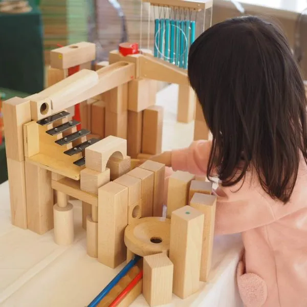 子どもが木製の積み木で遊ぶ手元のクローズアップ